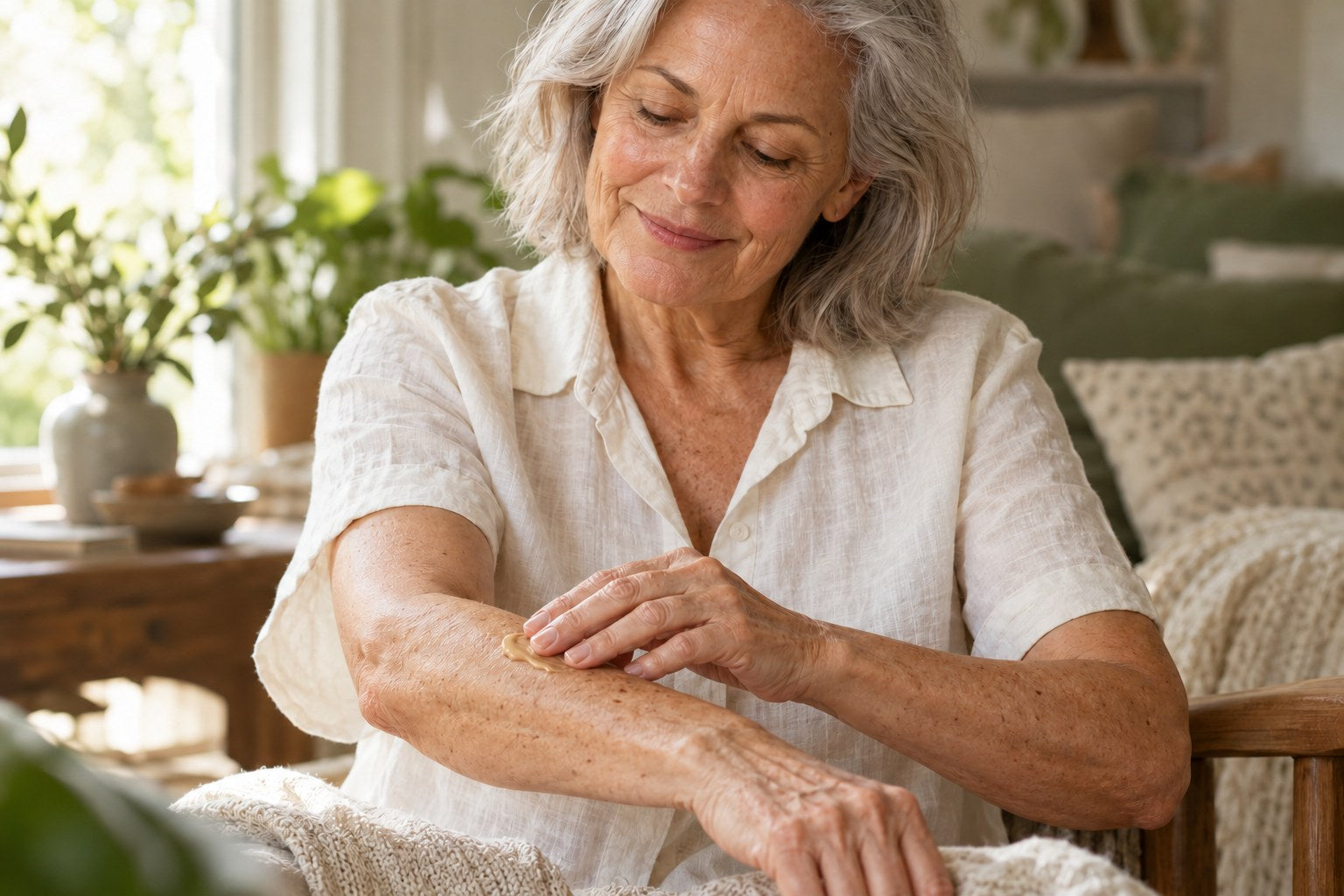Illustrative mature-skin routine: an older adult applying cream to a forearm